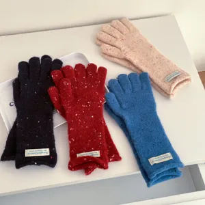 Detailed closeup of colorful speckled knit winter gloves, cozy warm five-finger design.