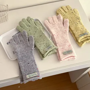 Detailed view of colorful speckled knit gloves for winter, warm woollen material with cute cuffs.