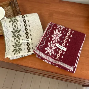 Primo piano di sciarpe invernali accoglienti in maglia con motivi di fiocchi di neve.