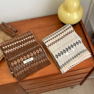 Close-up detail shot of cozy fair isle knitted winter scarves with soft wool blend texture.