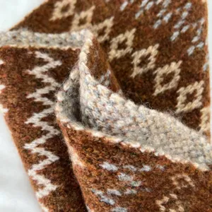 Wool blend knitted scarf detail shot, showing soft texture and cozy winter geometric pattern.