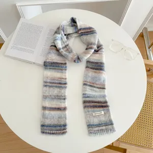 Close-up detail of the retro striped knitted scarf showing fine wool blend texture and soft knit.