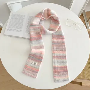 Detailed shot of retro color block knitted scarf, cozy pastel stripes design on table.