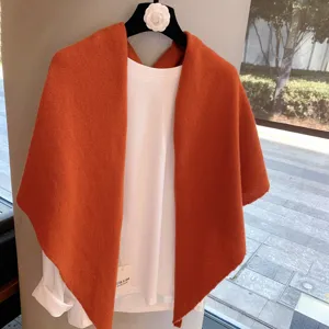 Orange knit triangular shawl for women, warm winter scarf and cozy apparel detail view.