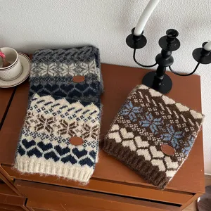 Vue détaillée de l'écharpe d'hiver en tricot style nordique avec motifs de flocons et cœurs.