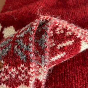 Gros plan detaille de la texture d'echarpe tricotuee rouge avec motif jacquard doux.