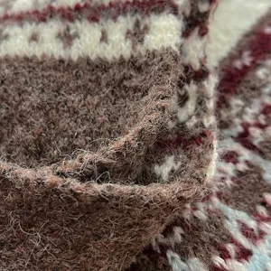 Detailed closeup of cozy Fair Isle knitted winter scarf, thick warm wool texture for women.
