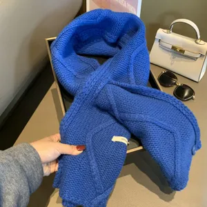 Primo piano dettagliato di una sciarpa in maglia blu vivace con morbida struttura in lana.
