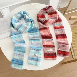 Close-up detail of cozy color-blocking knitted gradient scarves on a stylish white round table.