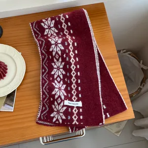 Accogliente sciarpa invernale in misto lana con classici motivi di fiocchi di neve e losanghe nordici.