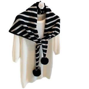Vintage striped knitted triangular scarf with pom-poms, warm winter cozy fashion accessory.