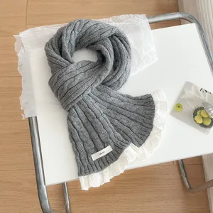Grey knitted scarf with white lace trim, cozy winter thermal neck warmer detail shot.