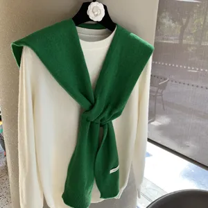 Écharpe en tricot vert avec pull en laine blanc, vêtement élégant d'automne pour femme.