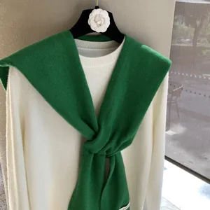 Châle d'épaule en tricot vert avec pull blanc en superposition, mode confortable automne hiver.