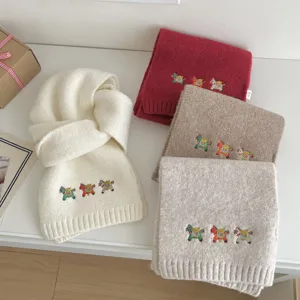 Cozy knitted winter scarf featuring cute embroidered little horse motifs, soft solid color.
