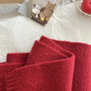 Cozy red knitted winter scarf detail, soft texture and warm solid color neckerchief.