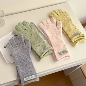 Detailed view of colorful knitted wool gloves featuring warm fabric and charming labels.