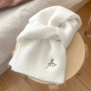 Nahaufnahme Detail eines weichen flauschigen weißen Plüsch Winterschlauchs mit grüner Pferd Stickerei.