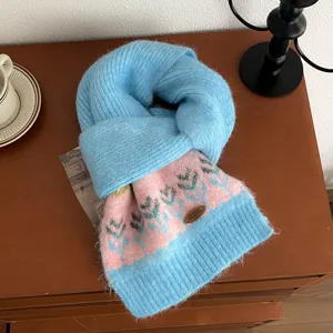 Close-up detail of cozy blue and pink knit winter scarf featuring classic Nordic patterned design.