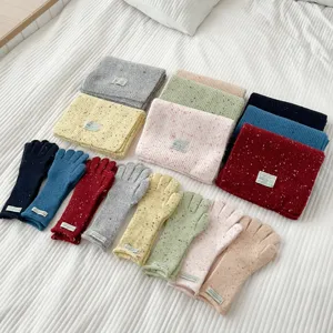 Detailed view of colorful knitted scarves and matching gloves set with cute speckle texture design.