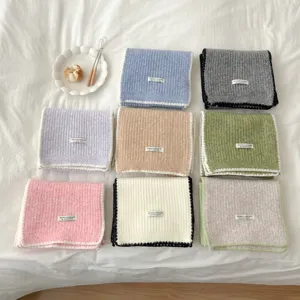 Minimalist solid color knitted scarf with contrast trim, flat lay view, cozy winter neckwear.