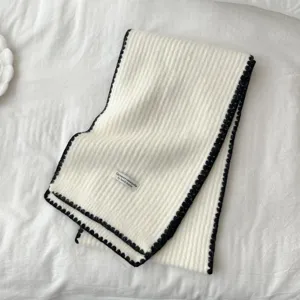 Cozy knit winter scarf in white with black scalloped edge, soft minimalist design for women.