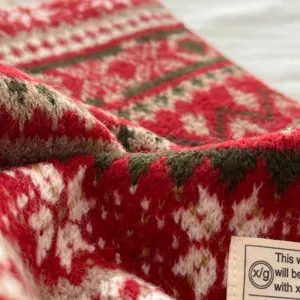 Close-up detail of the vintage Fair Isle patterned thick knitted winter scarf texture.