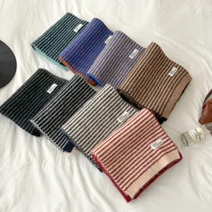 Detailed view of cozy striped knitted scarves in various colors, soft texture for winter.
