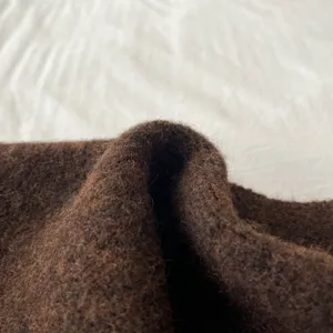 Close-up detail of the brown knit scarf showing thick warm woolen texture for autumn winter.