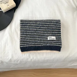 Detailed view of the cozy striped knitted scarf, soft textured wool knit, warm neck accessory.