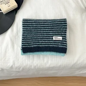 Detailed view of a soft striped knitted scarf in blue and black, cozy winter warm neck wear.