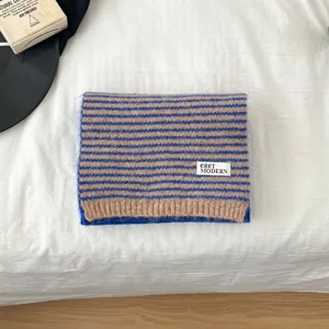 Detail view of a cozy brown and blue striped knit scarf, soft warm material for winter wear.