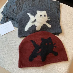 Detail view of winter wool knitted beanie with cute cat pattern, warm and soft fashion hat.