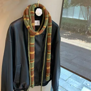 Green and brown striped narrow wool knit scarf detail, stylish retro scarf hanging display.