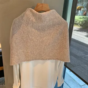 Detalle de chal de punto de lana gris con textura acogedora y estilo drapeado para otoño