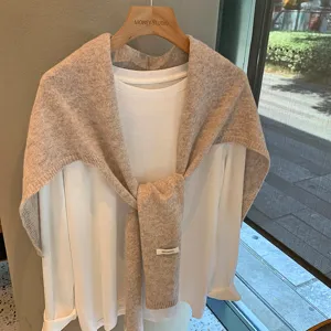 Detalle de chal de punto avena, bufanda de lana suave, estilo otoñal elegante y casual.