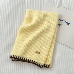 Cómoda bufanda de invierno de punto amarillo con borde de contraste marrón y elegante etiqueta.