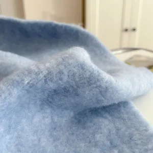 Close-up detail of soft light blue fuzzy winter scarf showing plush texture and warm fabric.