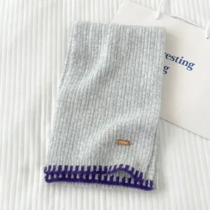 Bufanda de punto gris con borde morado de contraste y etiqueta de cuero FEIDE para invierno.