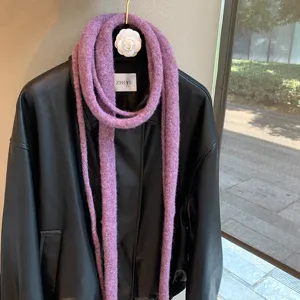 Close-up detail of the purple knitted long skinny scarf draped on black leather jacket.