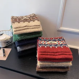 Detailed view of cozy Fair Isle knit scarves in assorted colors stacked neatly together.