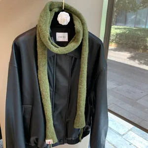Detail view of the solid olive green narrow wool long scarf, stylish knit baguette neck wrap.