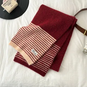 Cozy red and beige striped knitted scarf detail shot, warm winter neck accessory for women.