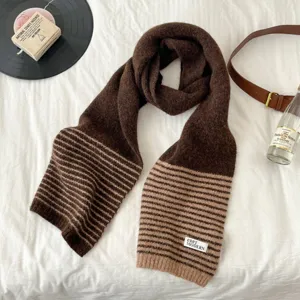 Brown striped knitted scarf detail showcasing the soft texture, cozy warmth and stylish hem label.