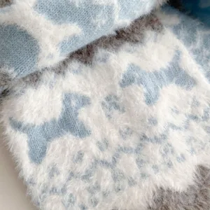 Close-up detail of a soft fluffy blue and white knit scarf featuring cozy winter texture.