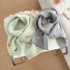 Detailed shot of soft knit scarves featuring delicate colorful butterfly embroidery designs.