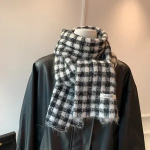 Black and white plaid knit scarf detail, cozy winter texture, soft woolen fabric accessory.