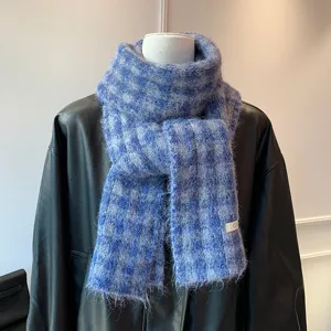 Detailed shot of a blue and grey plaid fluffy knitted winter scarf closeup texture display
