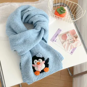 Cute blue knit scarf for women, short cross design with adorable penguin plush decoration.
