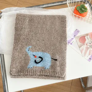 Cozy brown knit winter scarf featuring cute blue elephant embroidery. Soft short cross design.